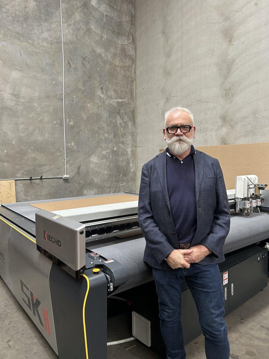 Daniel Bretag, co-owner, beside the digital cutting machine